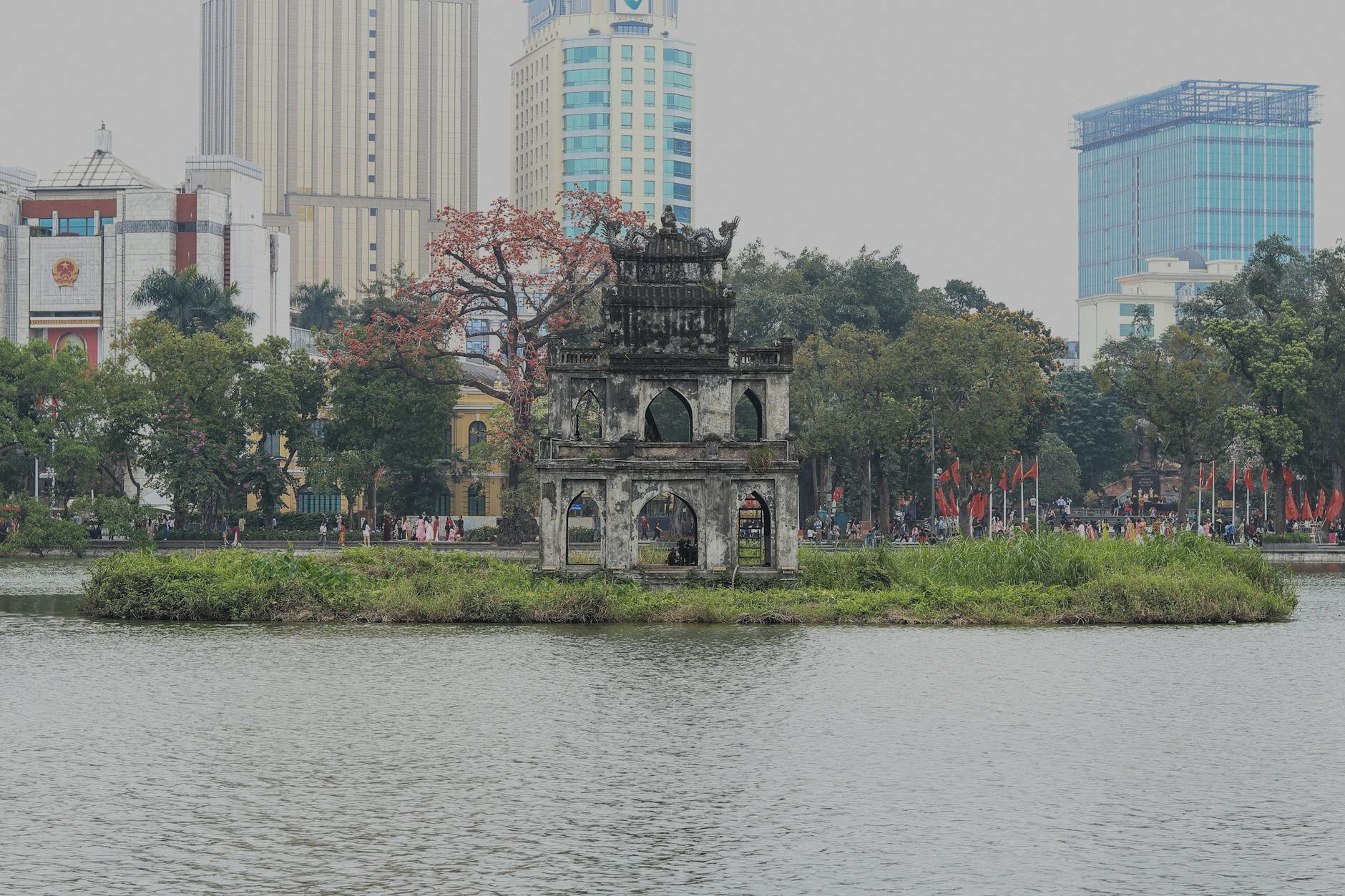 Free Things to Do in Hanoi: 30+ Budget Activities (2026) 1 Historic Turtle Tower on Hoan Kiem Lake with Hanoi modern skyline behind