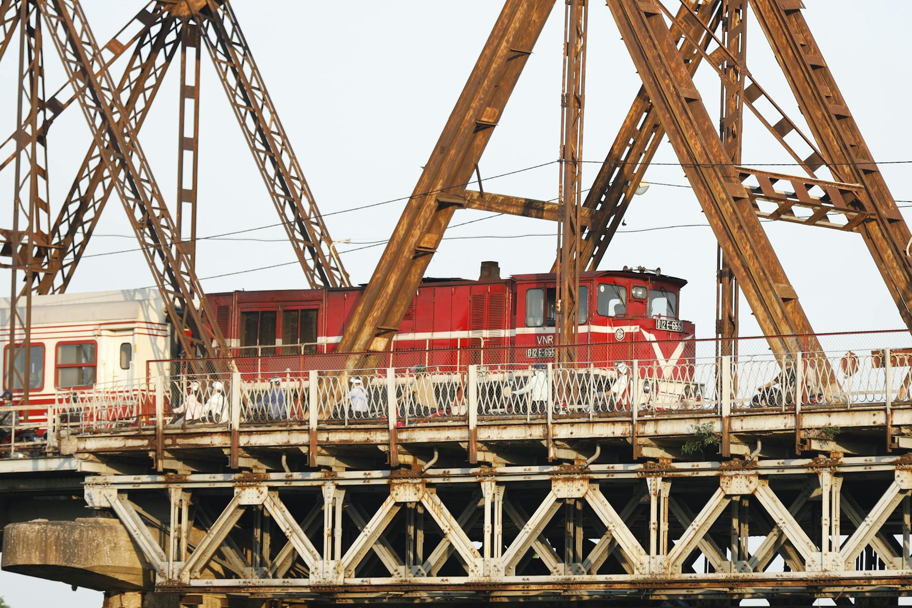 Free Things to Do in Hanoi: 30+ Budget Activities (2026) 3 Long Bien Bridge in Hanoi with a vibrant red train crossing it