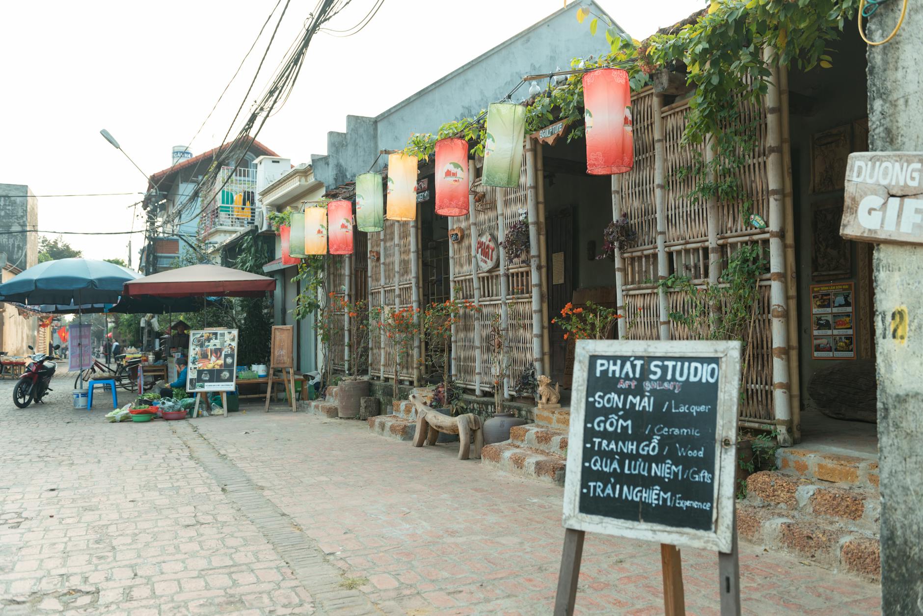 Hanoi 3-Day Itinerary: Perfect Route for First-Timers (2026) 1 Hanoi street with art studio, colorful lanterns, and local shops