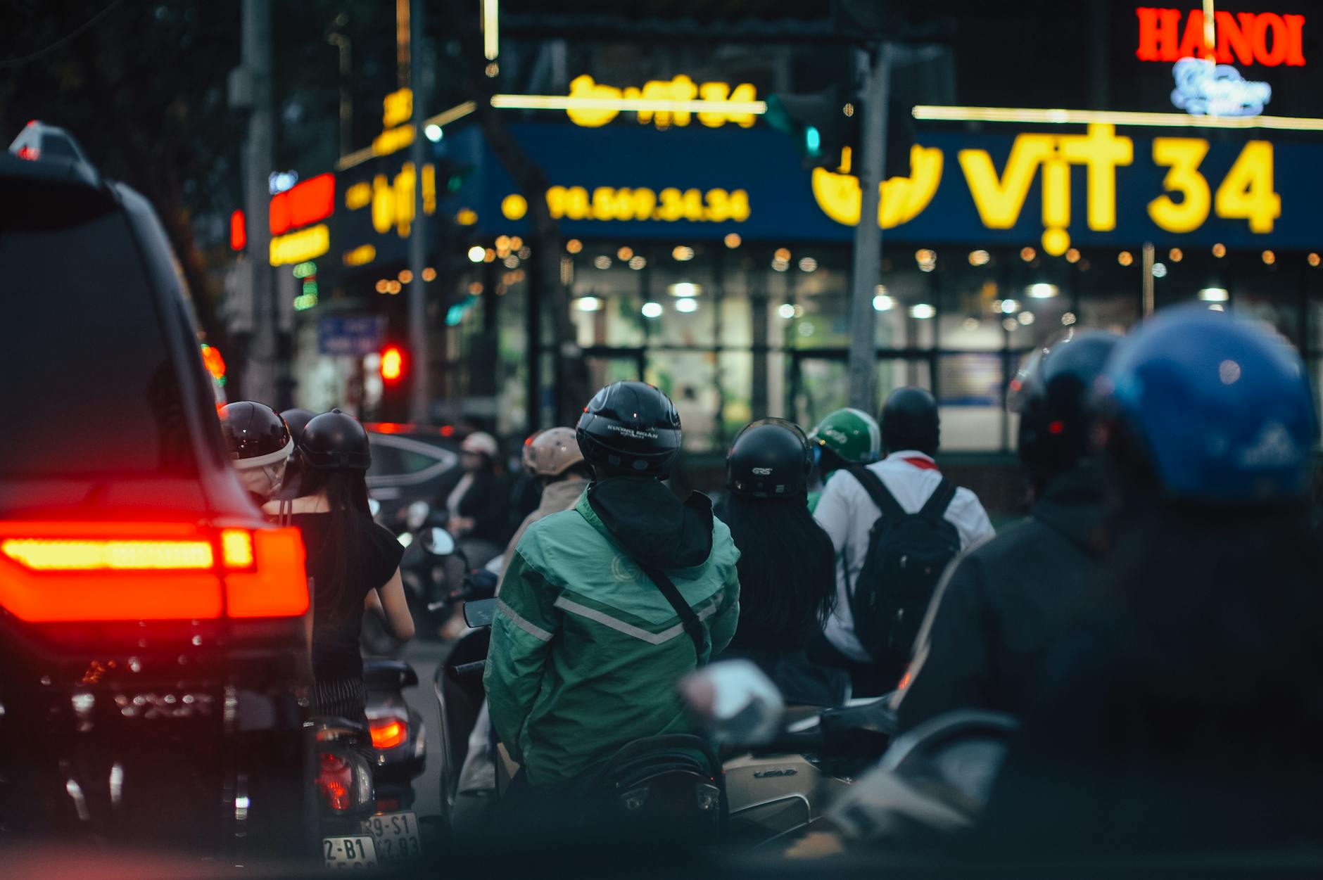 First Time Visiting Hanoi: Complete First-Timer's Guide (2026) 4 Bustling Hanoi street traffic with helmeted motorcyclists during evening rush hour