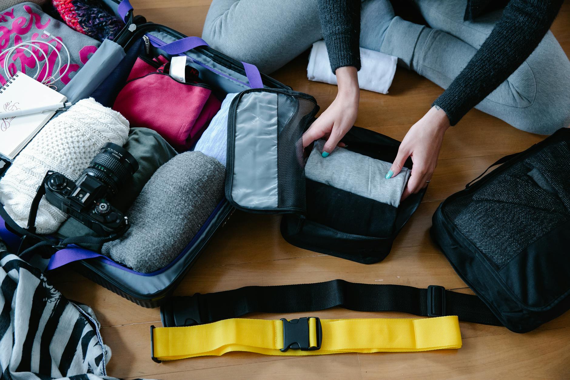 Hanoi Travel Checklist 2026: Complete Pre-Trip Essentials Guide 4 Woman organizing clothes and accessories into a suitcase for travel