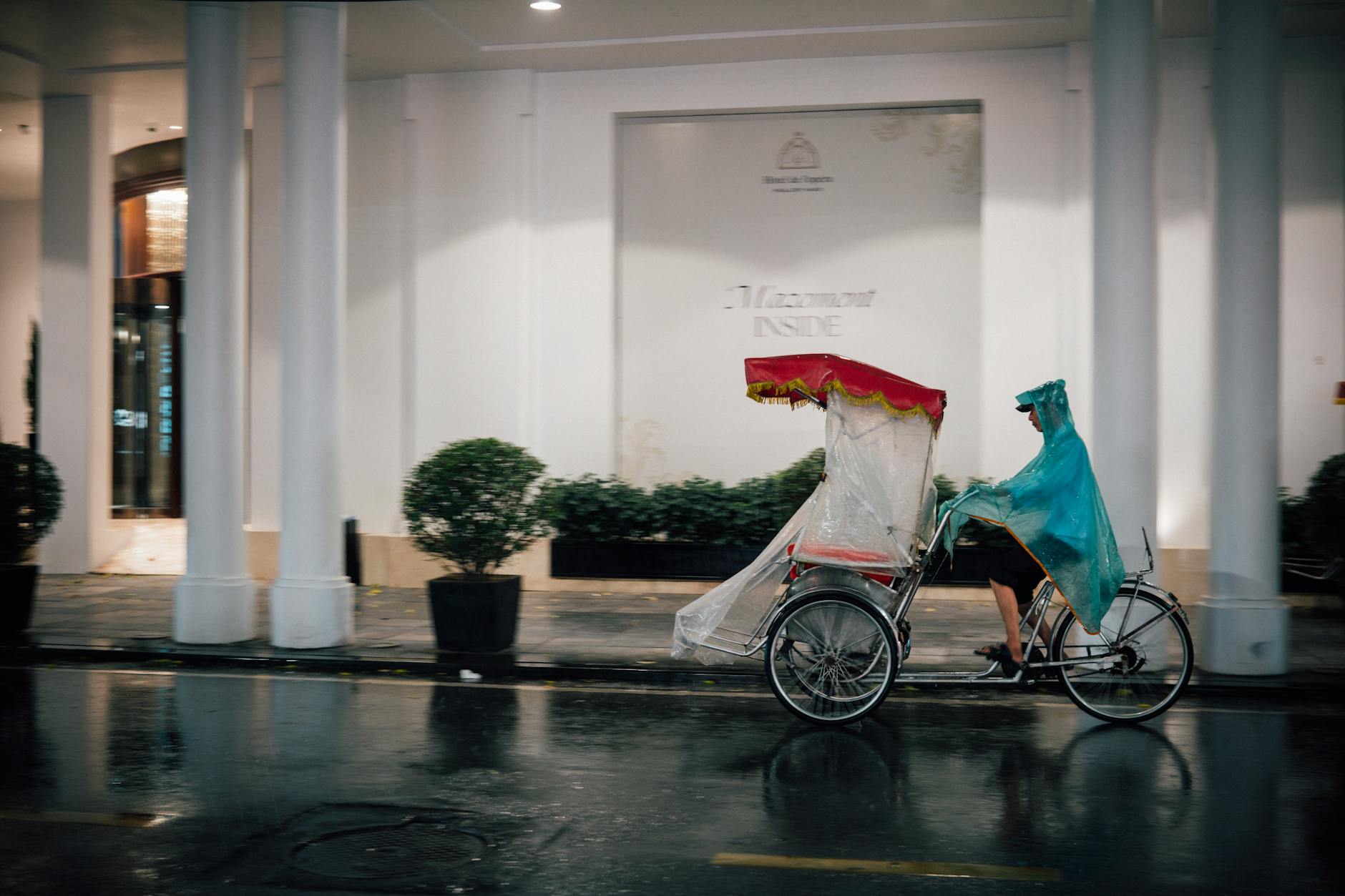 Hanoi Travel Checklist 2026: Complete Pre-Trip Essentials Guide 5 Cyclist in raincoat on a rainy Hanoi street with a cyclo passing by