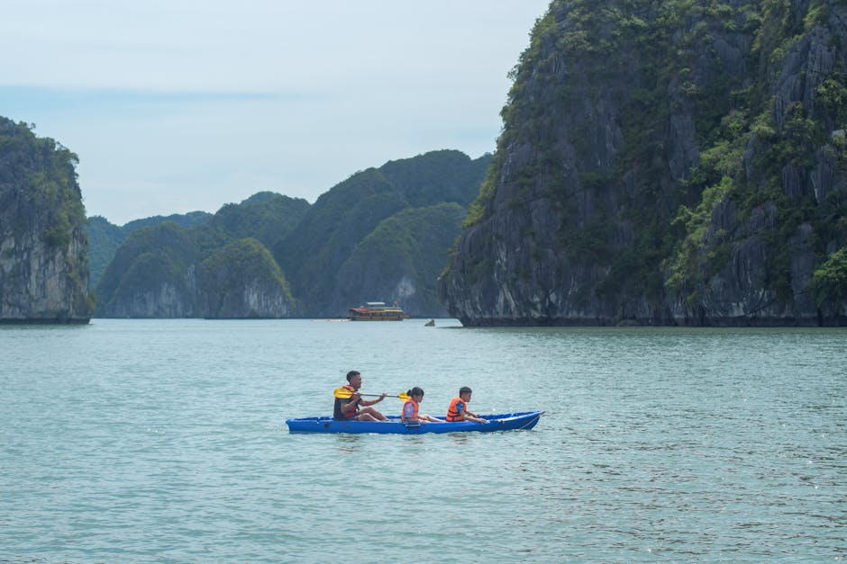 Family kayaking through limestone cliffs in Lan Ha Bay