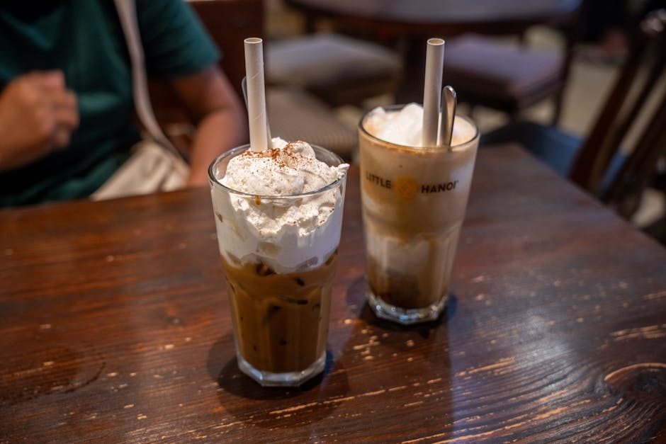 Hanoi Coffee Tour Guide: Brewery & Cafe Walks (2026) 1 Two iced coffee drinks with whipped cream