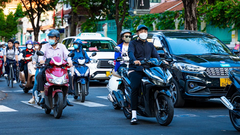 Grab Taxi Hanoi Guide: Booking, Costs & Tips (2026) 4 Scooters and cars crowding a busy Vietnamese street