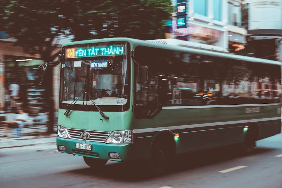 Hanoi Bus System Guide: Routes, Fares & Tips (2026) 2 Green city bus on busy Vietnamese urban street