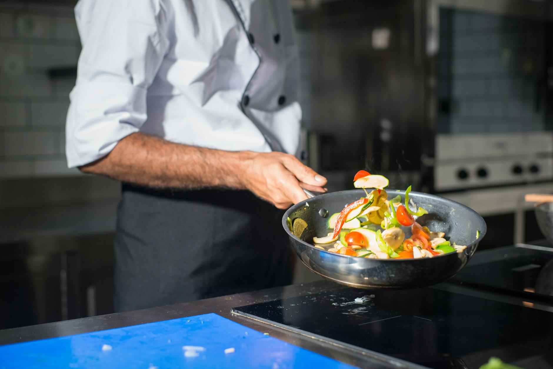 Hanoi Cooking Classes: 10 Best Vietnamese Cuisine Schools (2026) 2 Professional chef tossing fresh vegetables in a frying pan