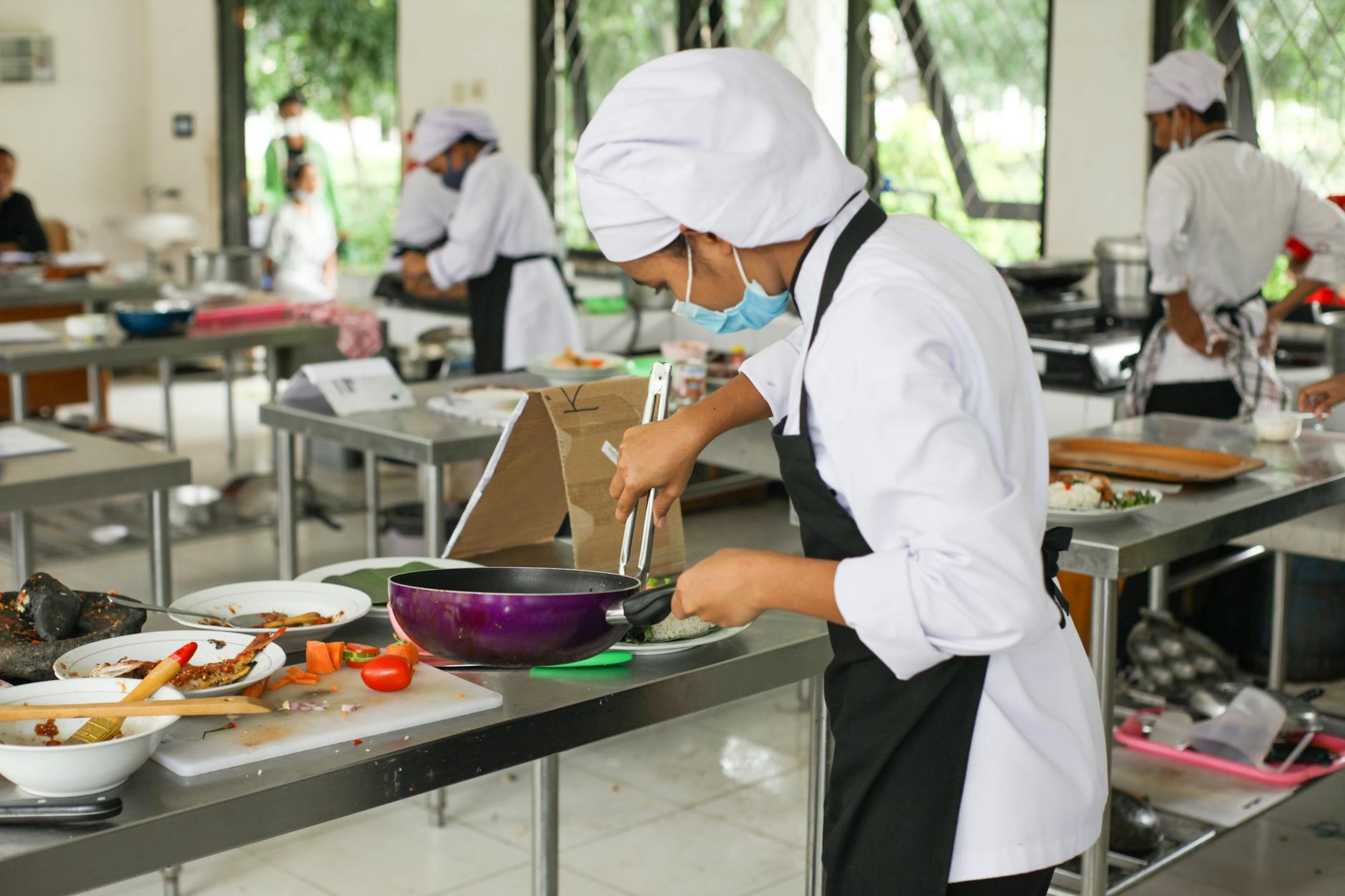 Hanoi Cooking Classes: 10 Best Vietnamese Cuisine Schools (2026) 4 Culinary students in uniforms practice cooking skills