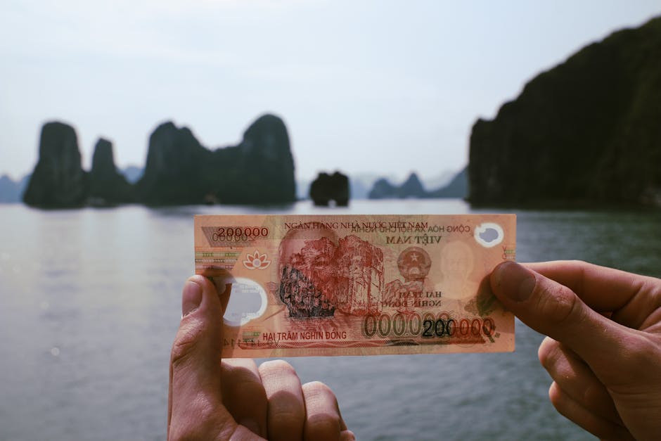 Hanoi Money & Currency Tips: Payment Guide (2026) 2 Hands holding Vietnamese Dong with Halong Bay