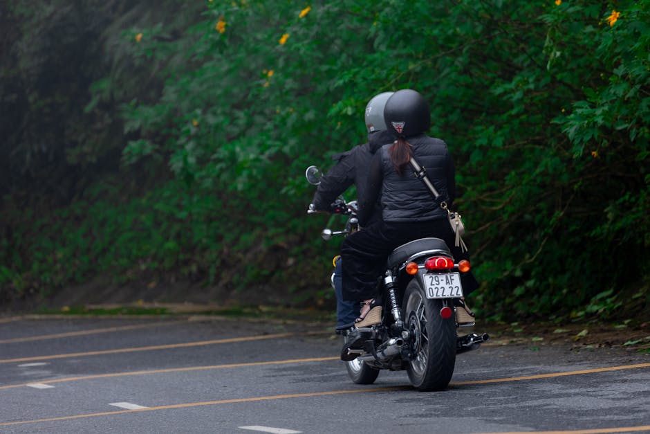 Motorcyclists riding through green road in Hanoi