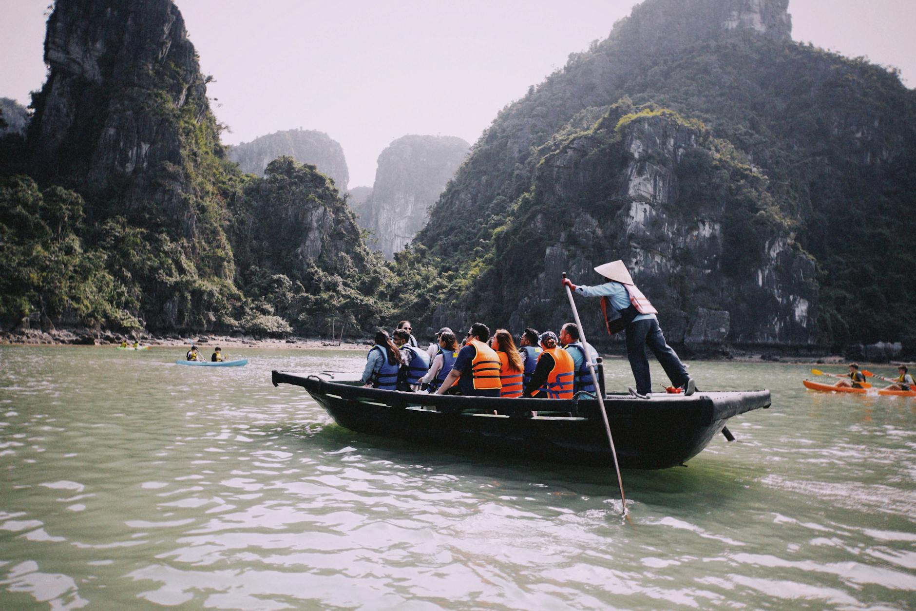 Ninh Binh Day Trip from Hanoi: Complete Guide (2026) 2 Tourists in life jackets enjoying a rowboat ride through karst landscape