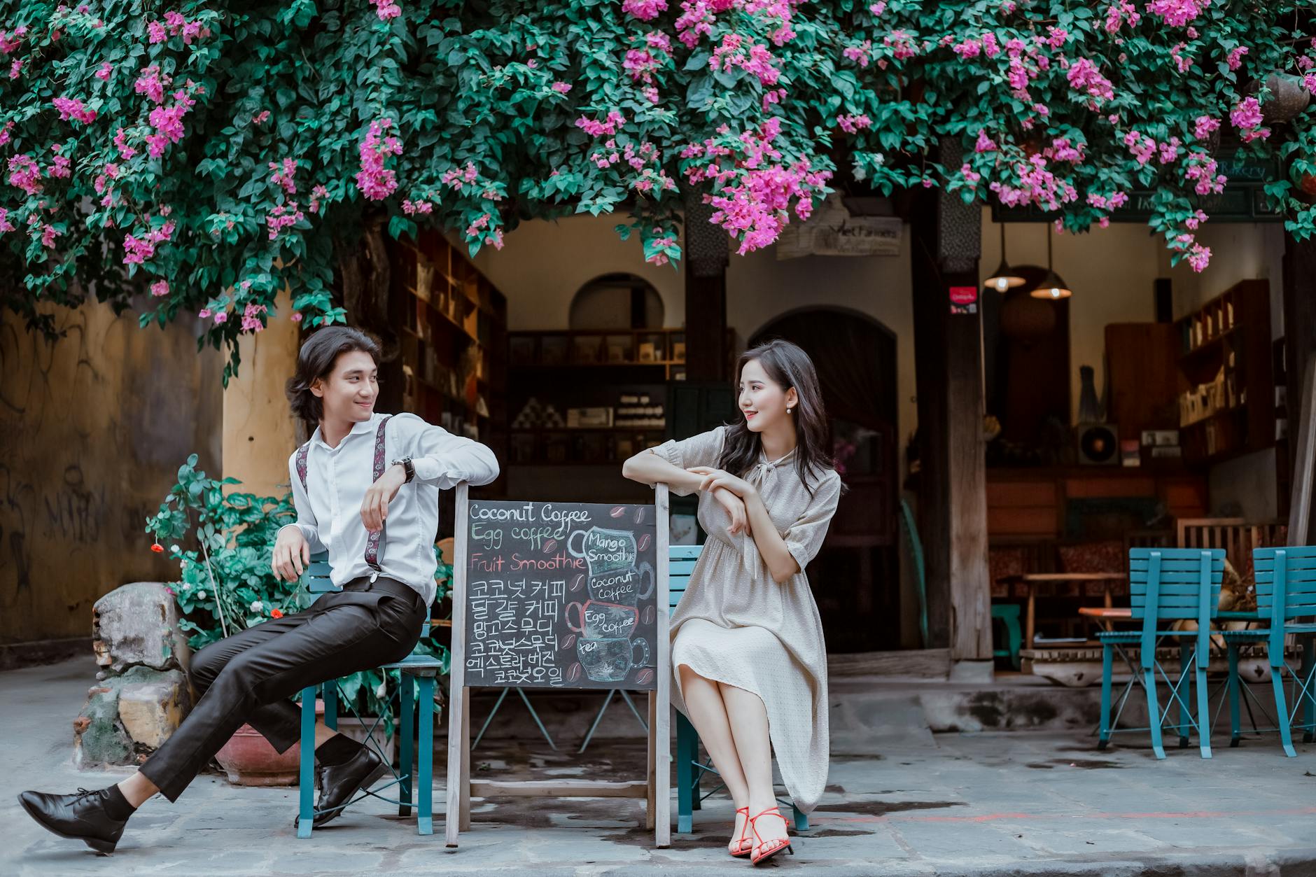 Couple enjoying a cozy moment at a Vietnamese café surrounded by florals