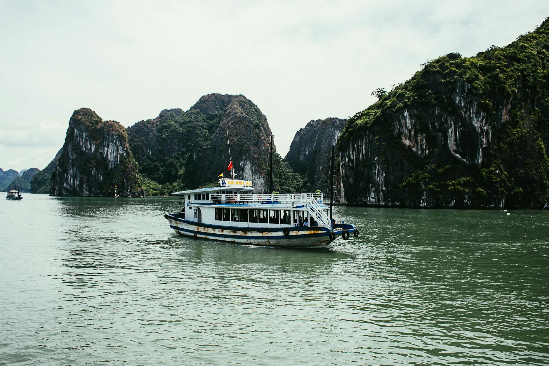 Tranquil cruise boat sailing through emerald waters of Halong Bay