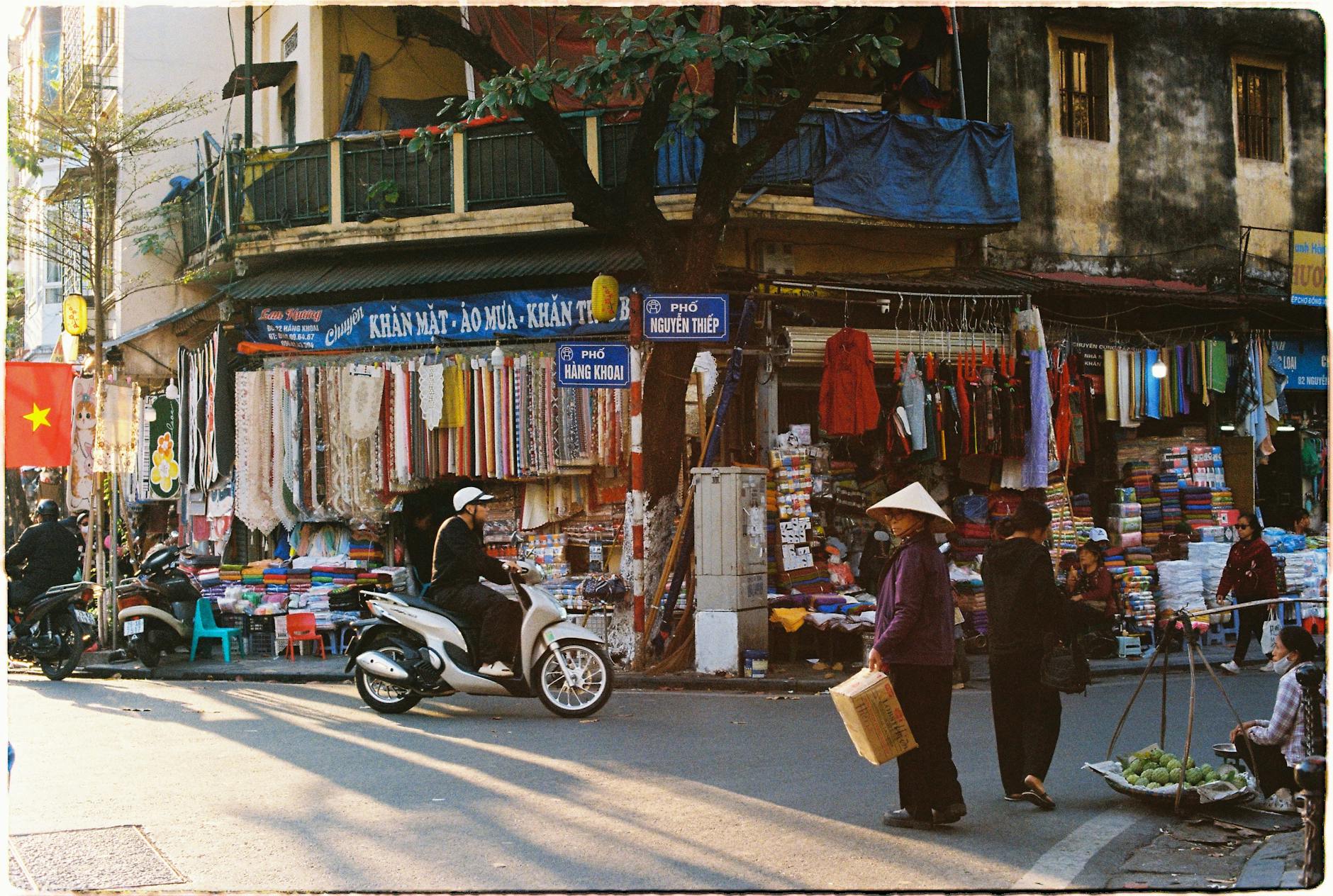 Shopping in Hanoi Old Quarter: Markets & Best Streets (2026) 2 Vibrant Hanoi street market with people and colorful fabrics