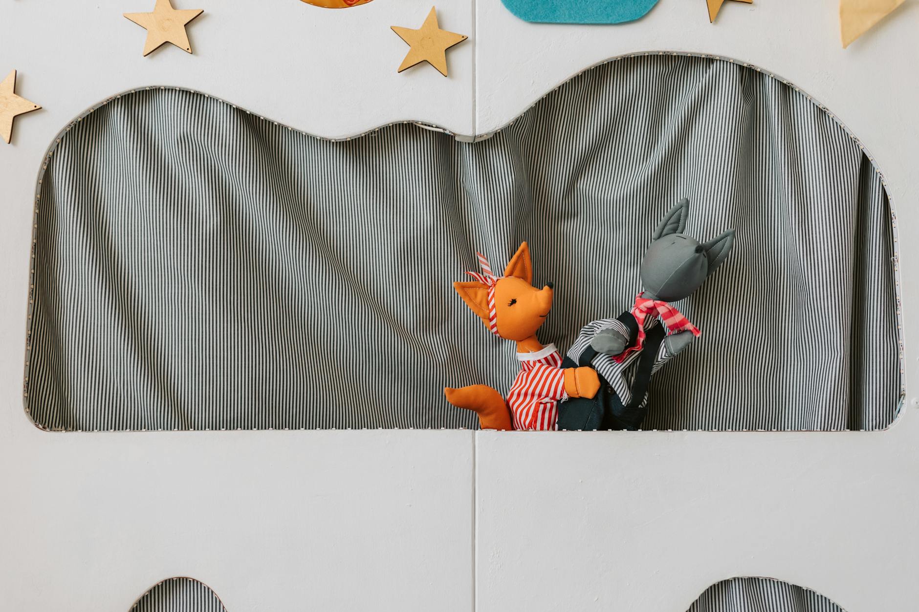 Bright puppet theater setup with two animal puppets performing on stage